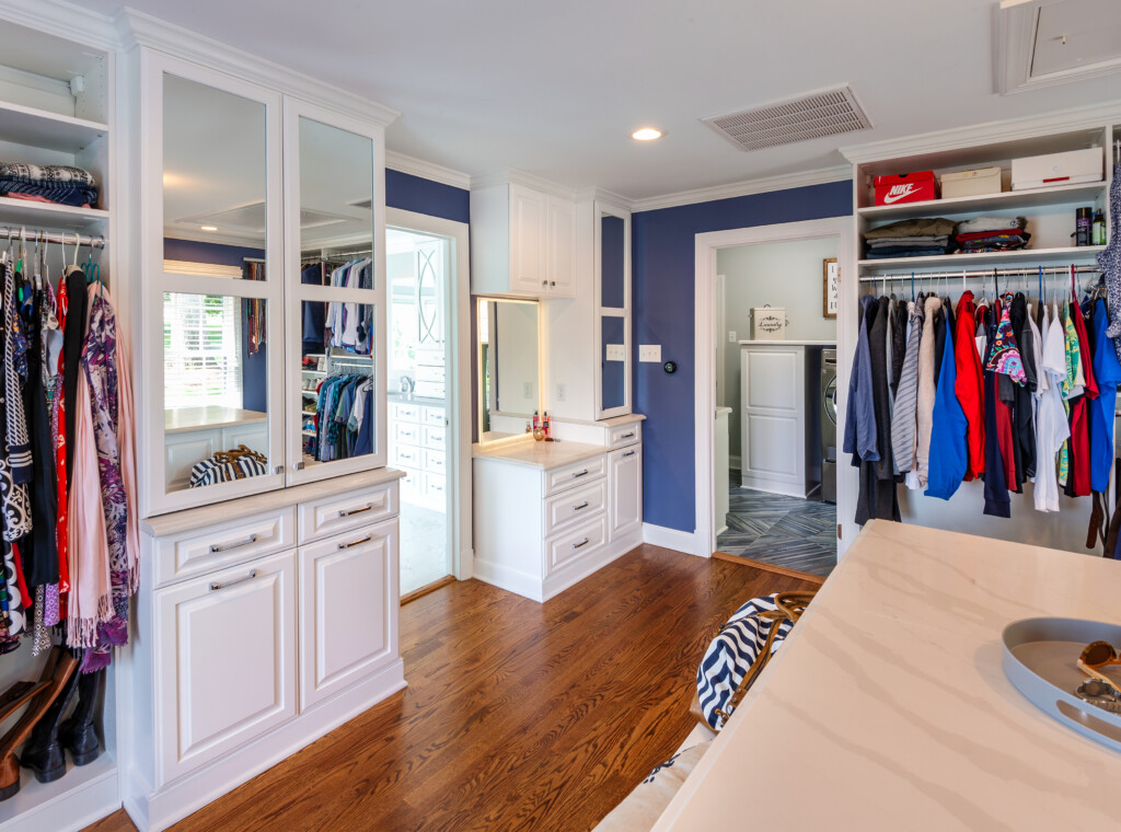 Closets of Virginia custom system in a luxury closet remodel featuring a built-in vanity with a lighted mirror.